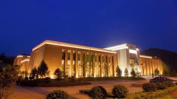 A large building with a modern architectural style, featuring a prominent entrance and a well-lit facade.