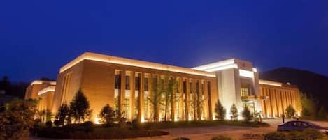 A large building with a modern architectural style, featuring a prominent entrance and a well-lit facade.
