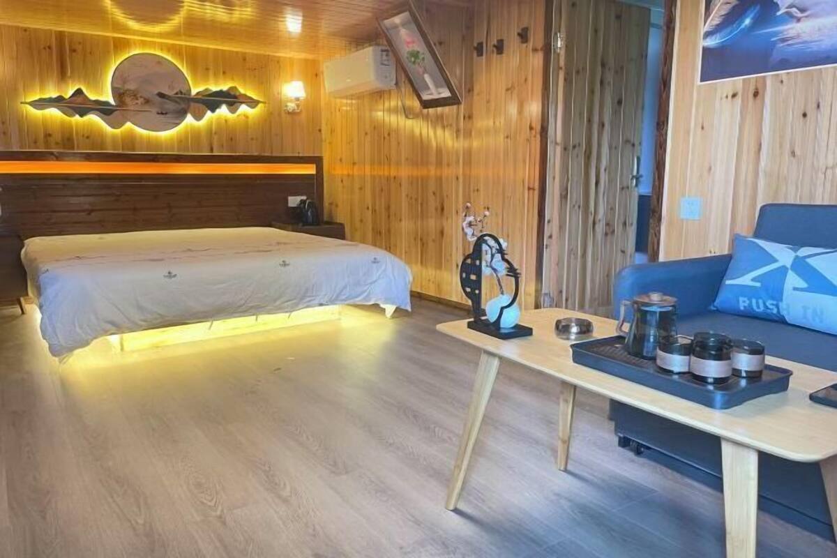 A wooden-themed room with a bed, a small table with a tray, and a sofa with a pillow that says "RUSSIA".