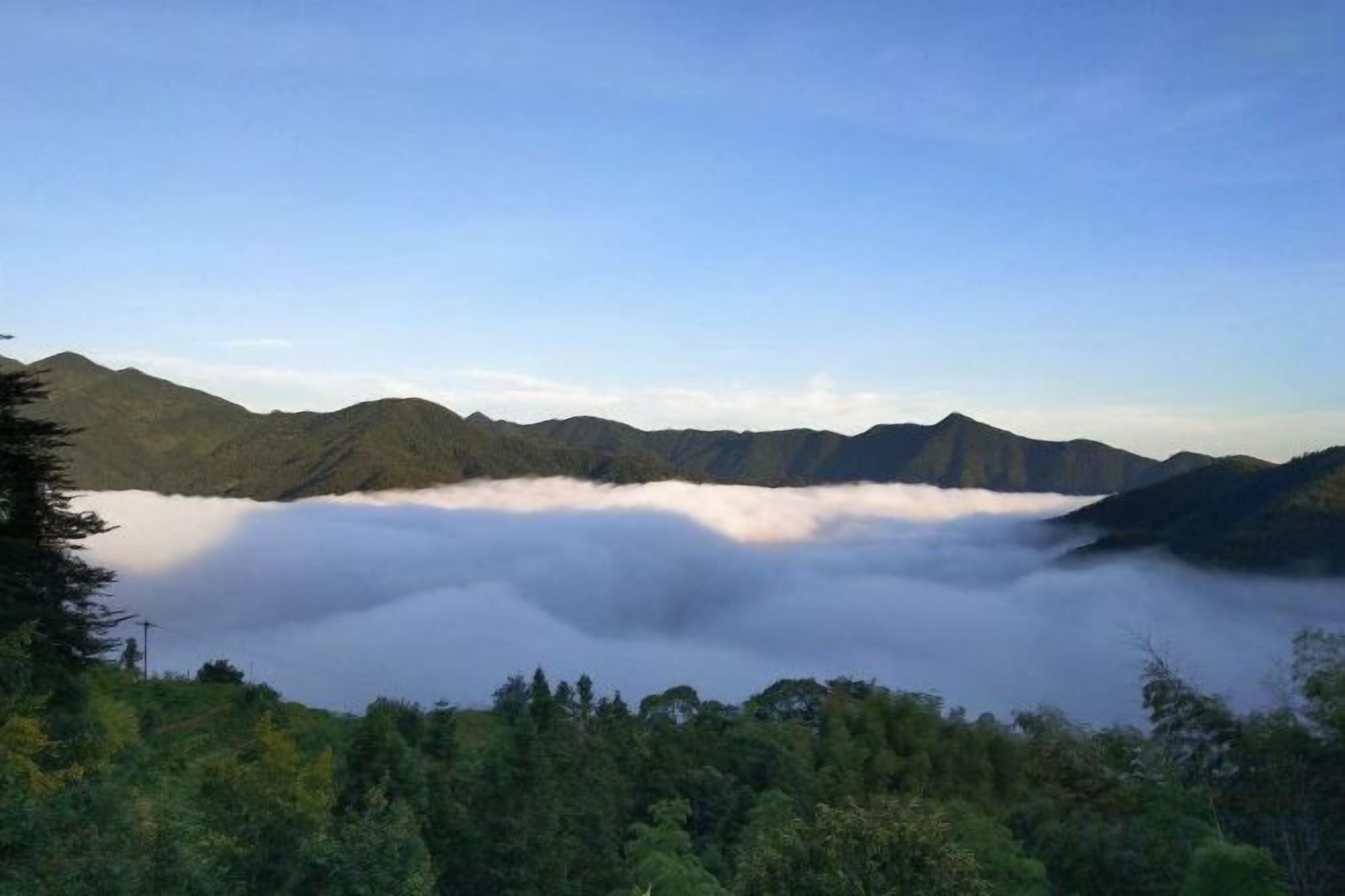 A mountainous landscape with a valley shrouded in mist.