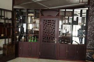 A traditional room with a wooden cabinet, a decorative screen, and a mirror.
