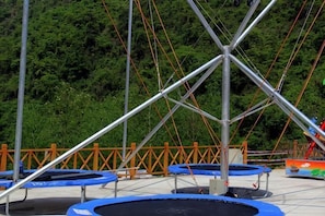 A trampoline park with multiple trampolines and a metal structure in the center. - Happy Valley Manor (Danjiangkou)