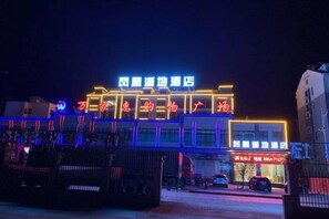 A hotel with illuminated signage and a covered outdoor area. - Fenghuag Xidi Hotel (Jinzhai)