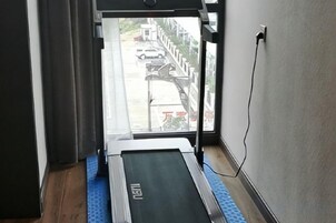 Una cinta de correr en una habitación con ventana que da a la calle.