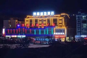 Un hotel con fachada moderna, señalización iluminada y una entrada destacada.