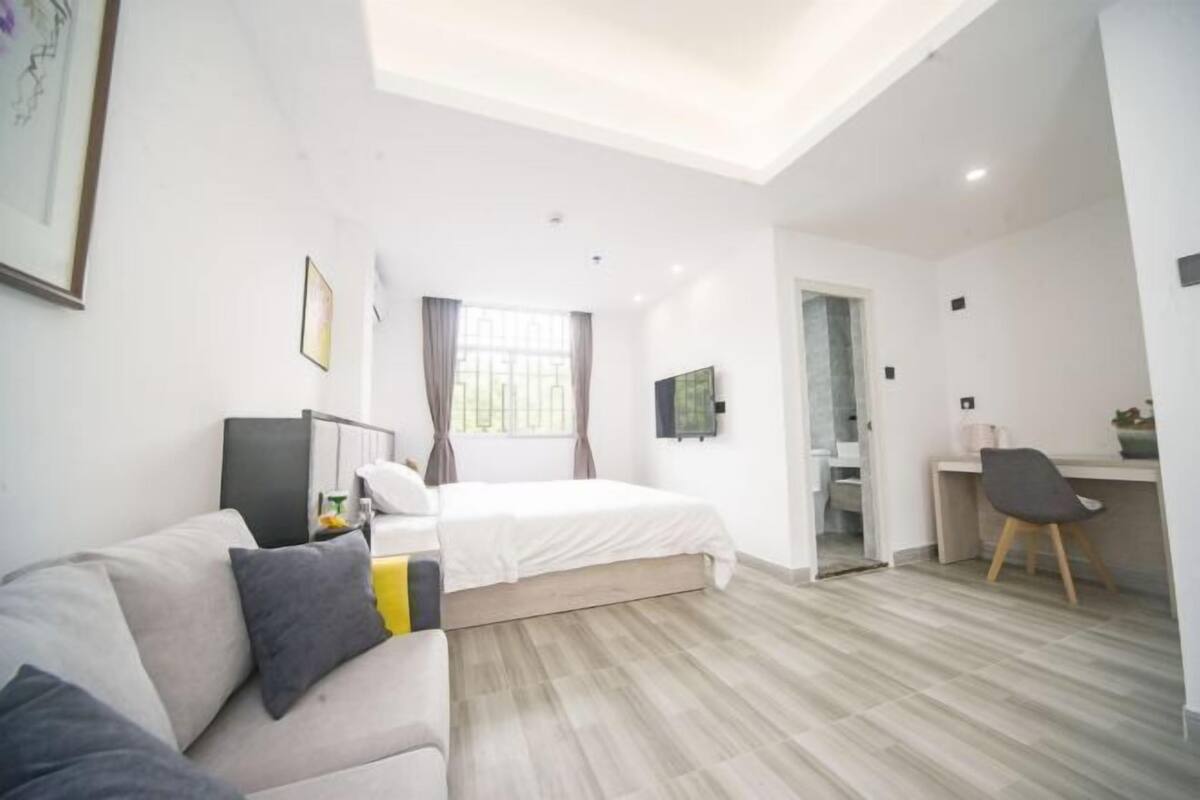 A modern bedroom with a bed, a desk, and a chair.