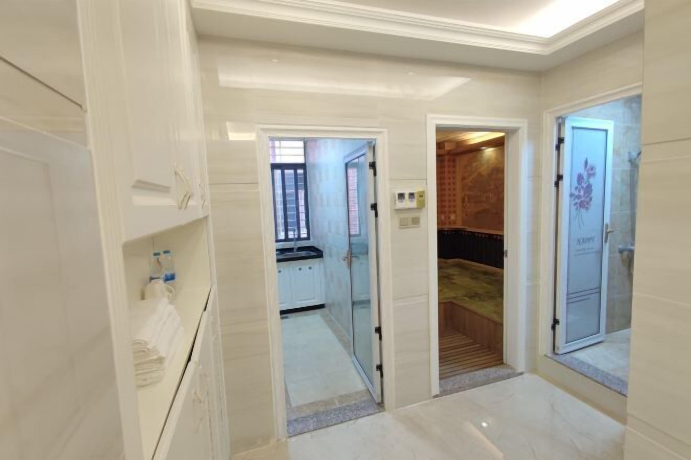 Een moderne hotelkamer met een badkamer, een kleine kitchenette en een apart toilet.