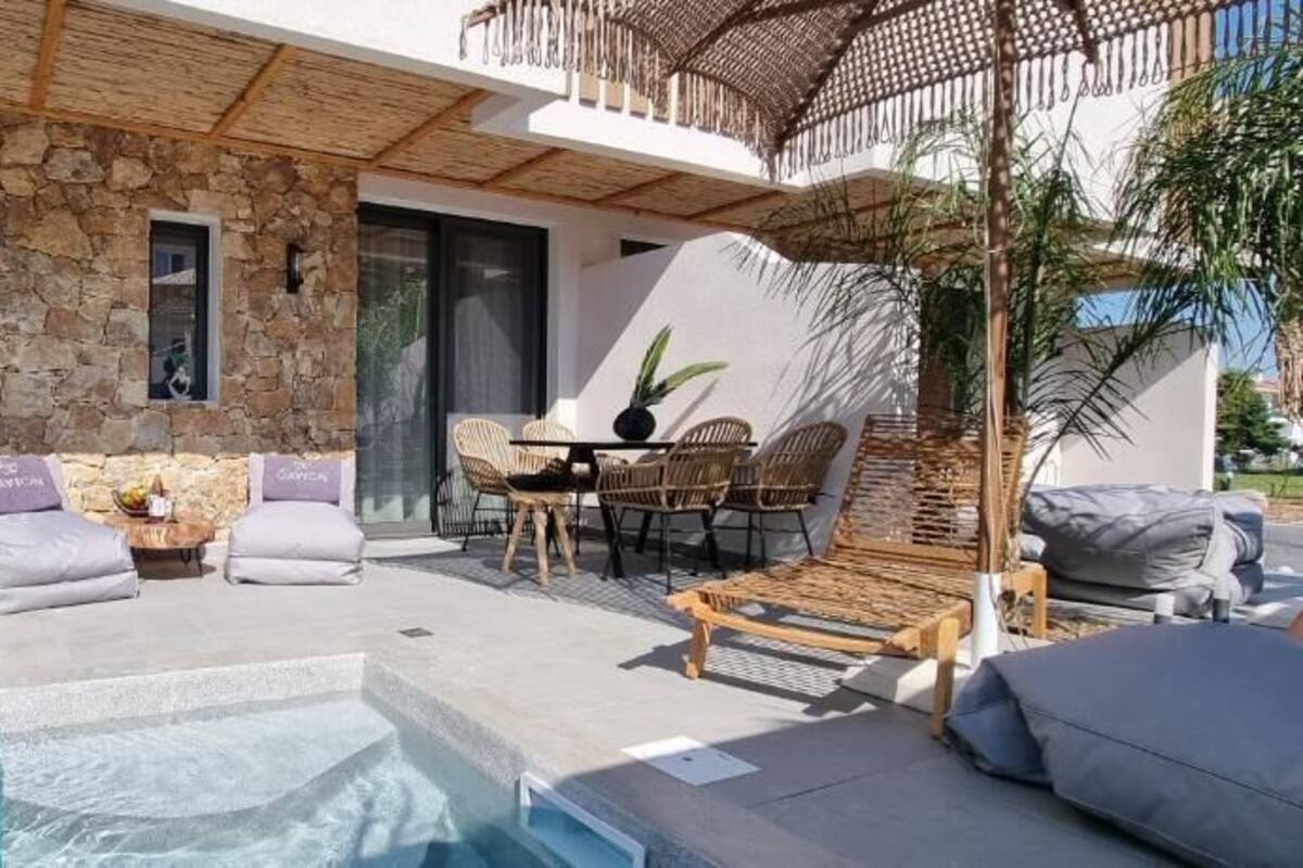 Ein moderner Poolbereich im Freien mit einer Steinwand, Schiebegläsern und einer Holzpergola.