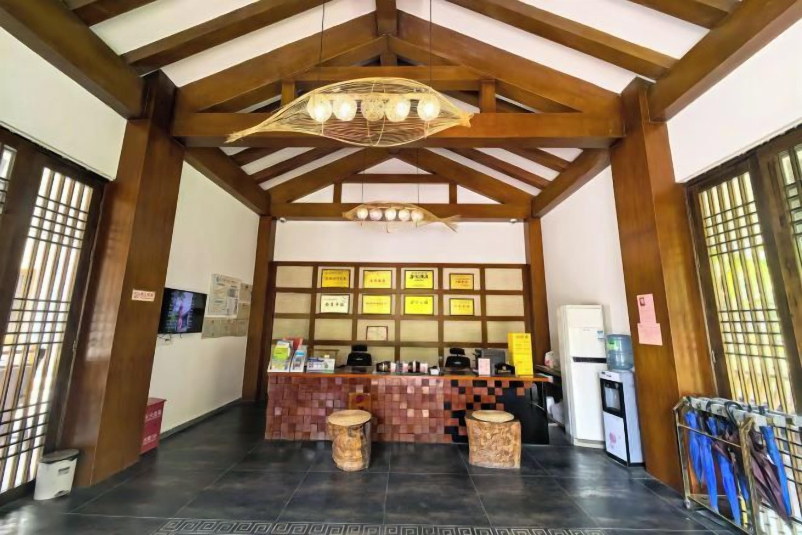 A reception area with a counter, framed certificates, a refrigerator, and a television.