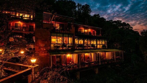 A multi-story building with a glass facade, surrounded by trees. - Taole Forest Hostel (Chongqing)