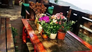 Um deck de madeira com um banco e plantas em vasos.