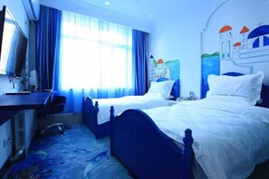 Une chambre d’hôtel avec deux lits, un bureau, une chaise, une télévision et une fenêtre avec des rideaux.