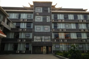 Un edificio de varios pisos con entrada central, unidades de aire acondicionado y un estilo arquitectónico tradicional.