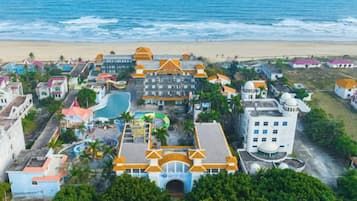 An aerial view of a coastal resort with multiple buildings, a beach, and a water park.