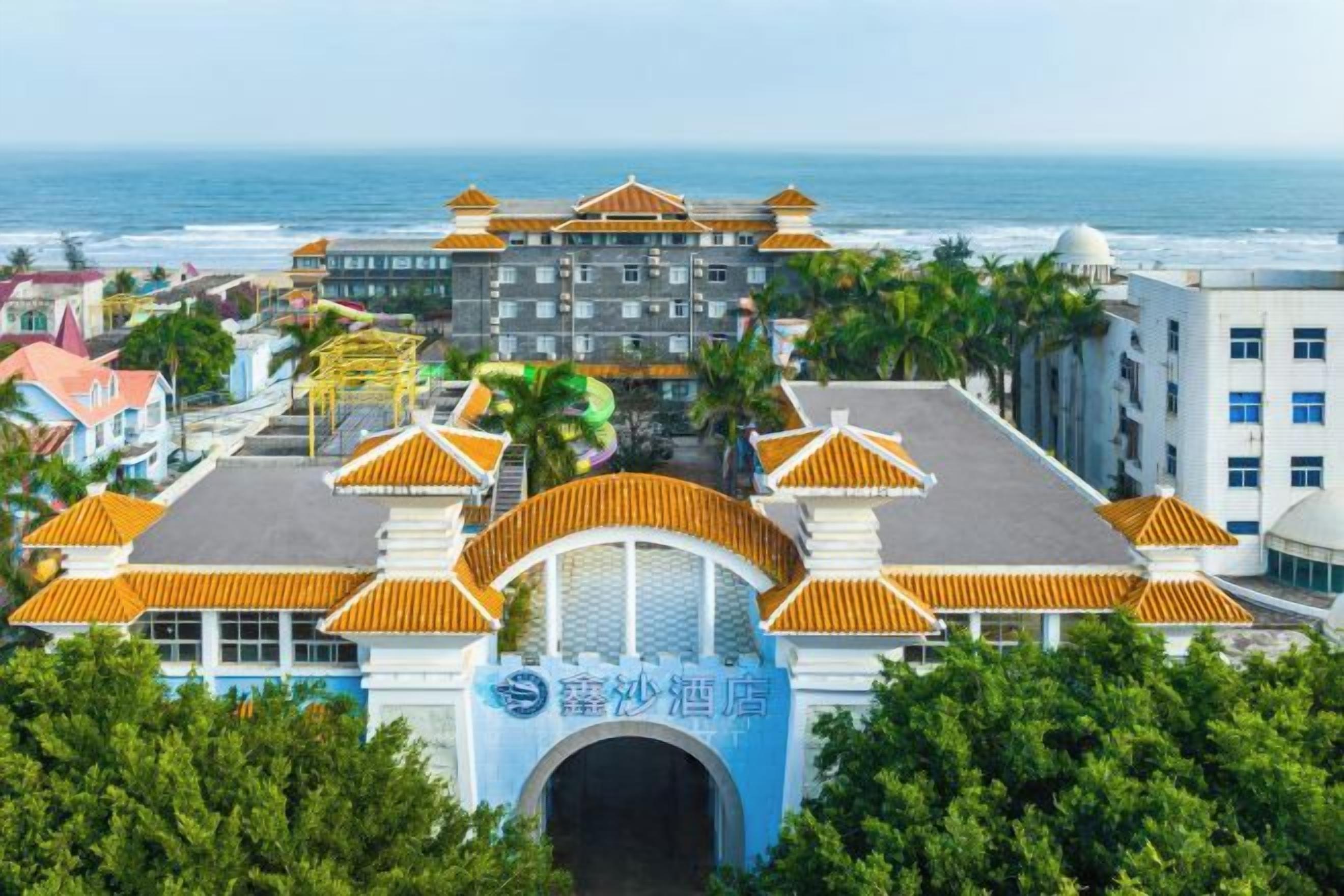 A hotel with a traditional architectural style, featuring a central archway and multiple buildings with orange roofs.