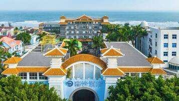 A hotel with a traditional architectural style, featuring a central archway and multiple buildings with orange roofs.