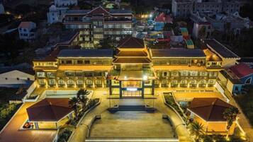 A large, multi-story building with a central courtyard, surrounded by smaller structures.