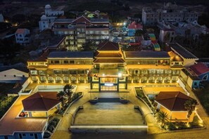 Un edificio grande de varios pisos con un patio central, rodeado de construcciones más pequeñas.