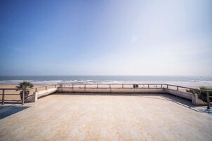 Una terraza frente a la playa con vistas al océano.