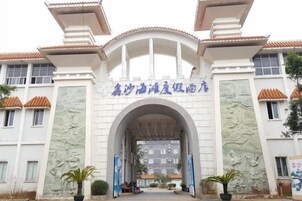 Una entrada de edificio con un arco, un letrero con caracteres chinos y un tejado de baldosas.