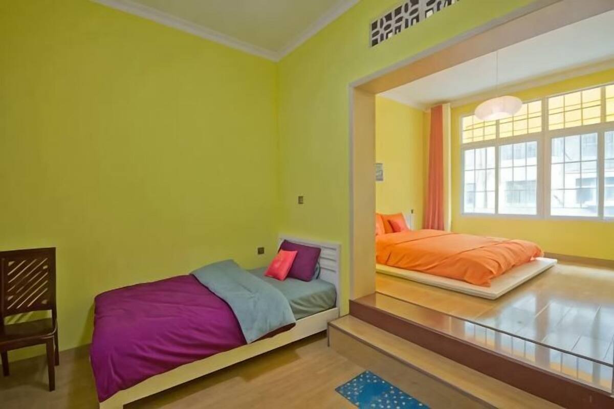Ein Zimmer mit Bett, Stuhl und Fenster.