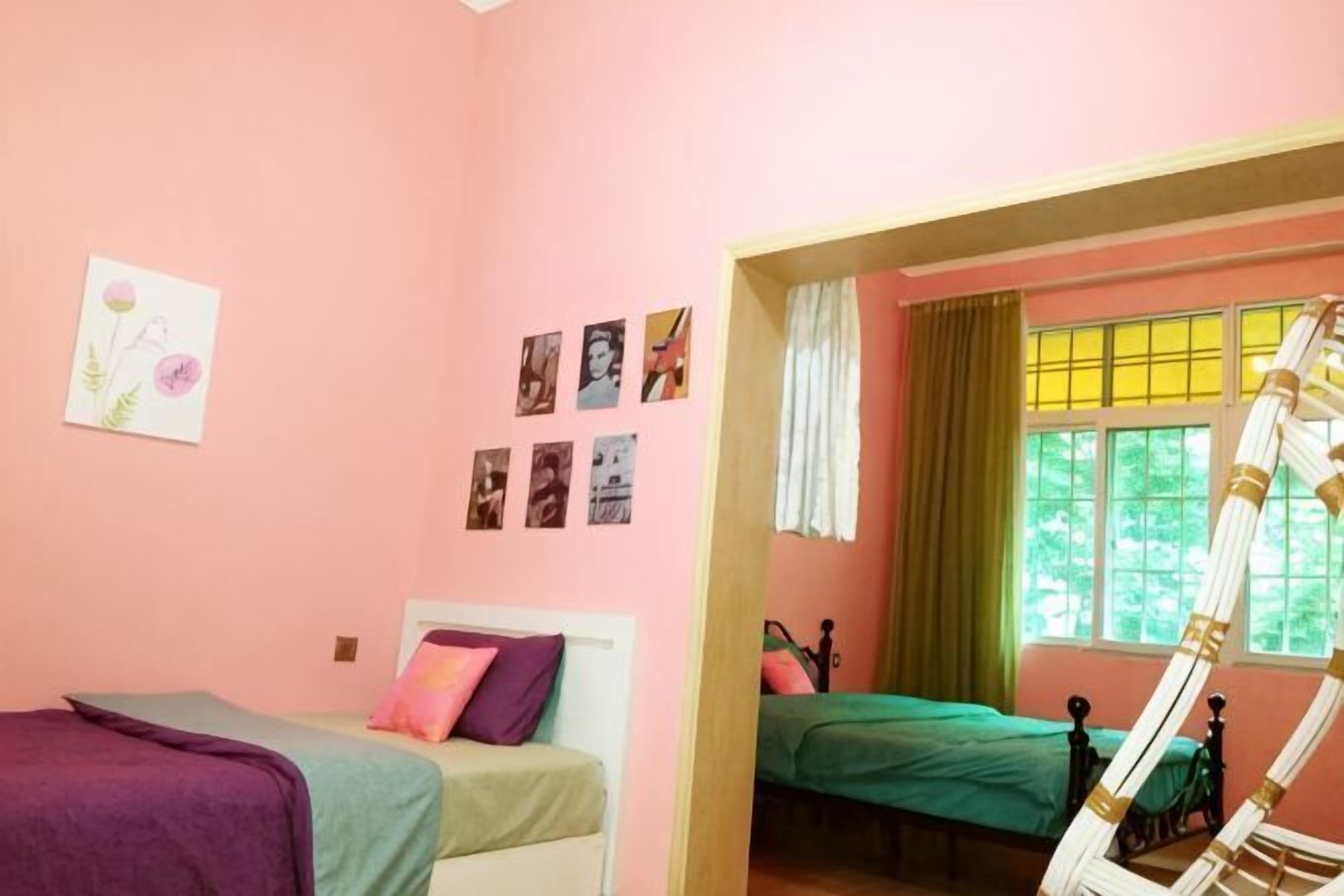 Un dormitorio con dos camas, una ventana con cortinas y una escalera para la cama.