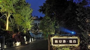 Un sendero que lleva a un edificio con un cartel que dice '山豆处·谦卑'.