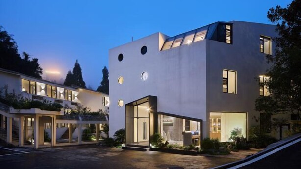 Un edificio moderno con múltiples ventanales y una entrada bien iluminada.
