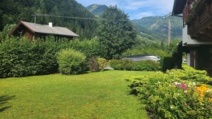 Un paysage montagneux avec une pelouse bien entretenue et un chalet en bois.