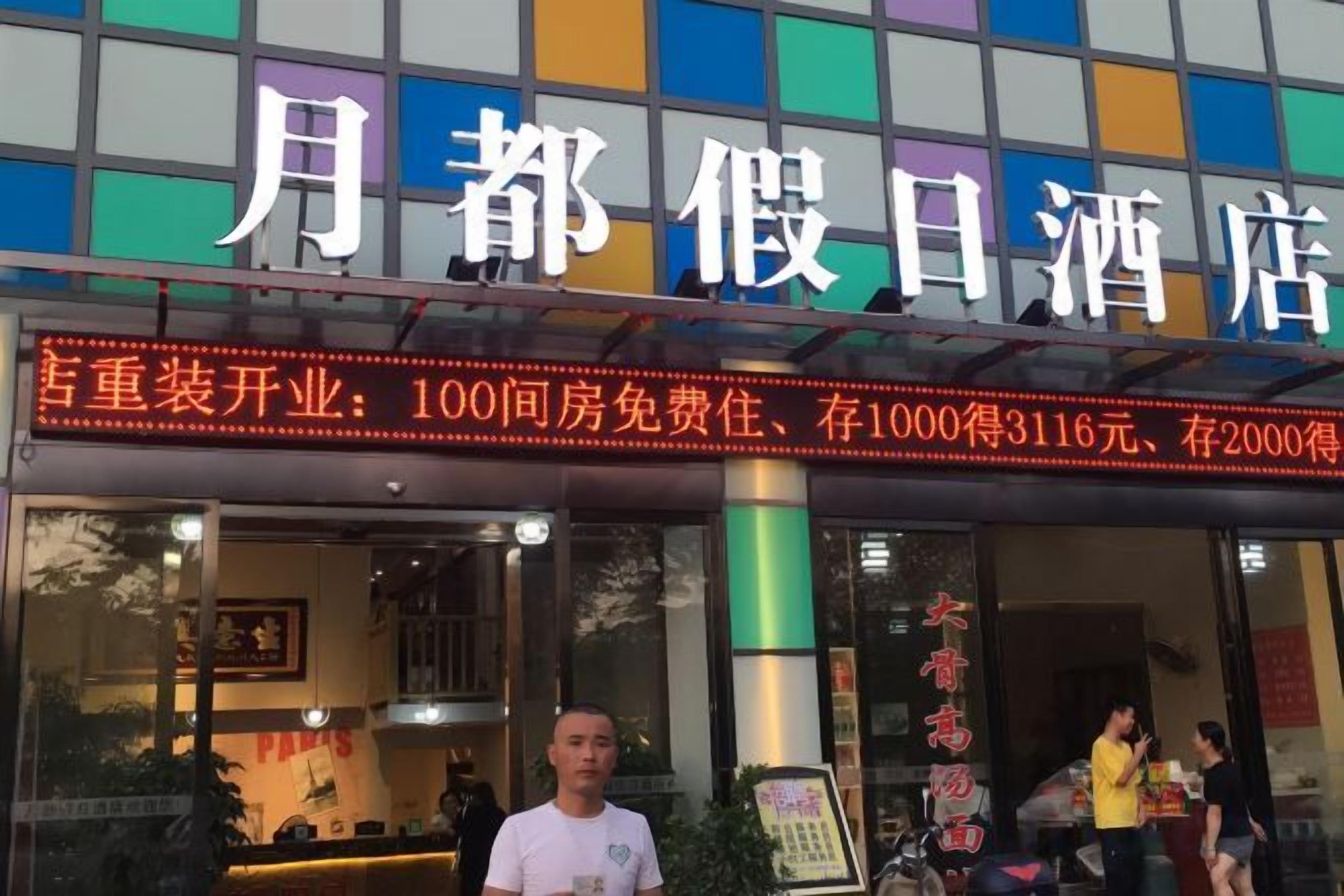 Un hotel con un cartel grande que indica tarifas y servicios.