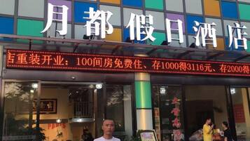 Un hotel con un cartel grande que indica tarifas y servicios.