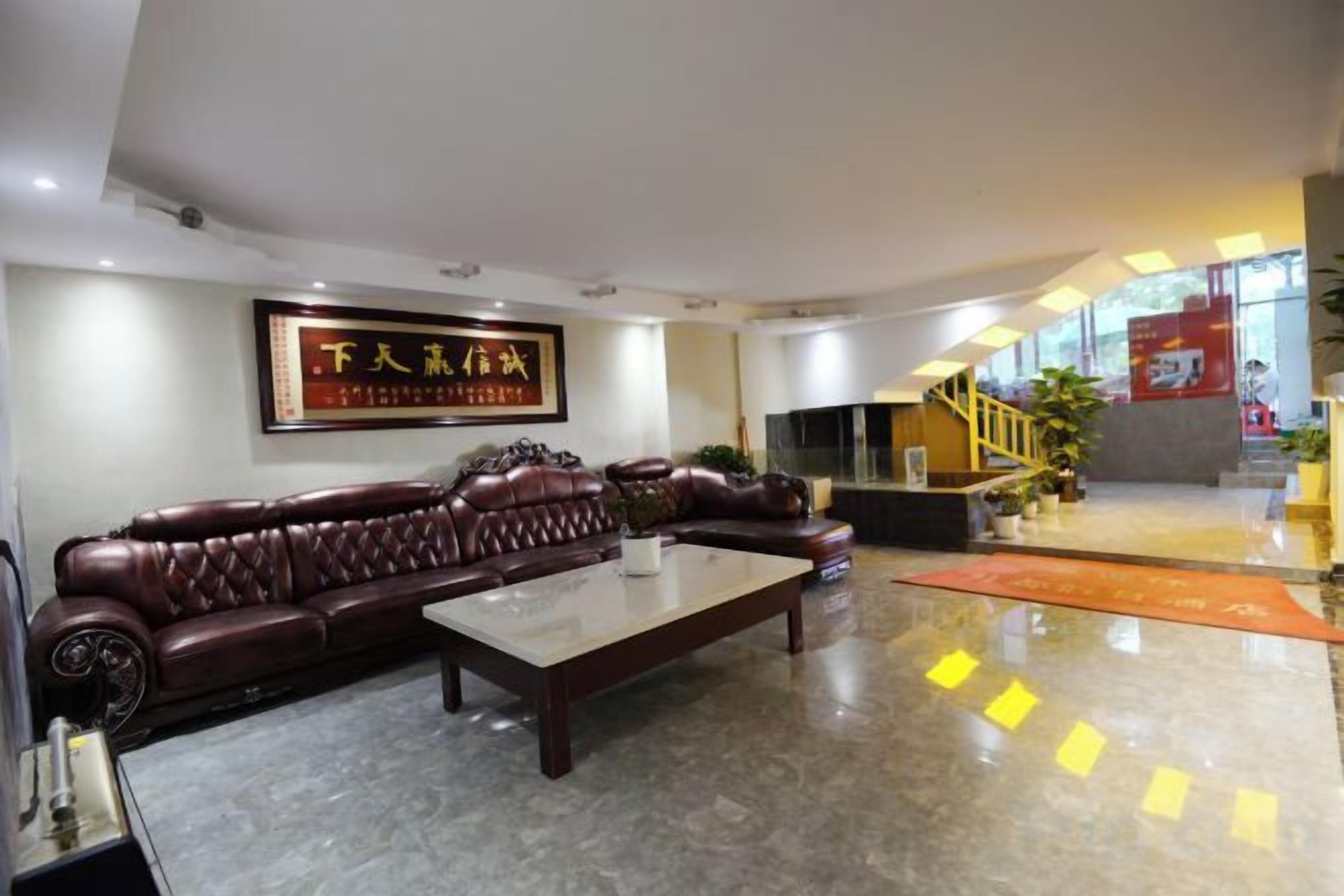 A modern living room with a leather sofa, a coffee table, and a framed artwork on the wall.