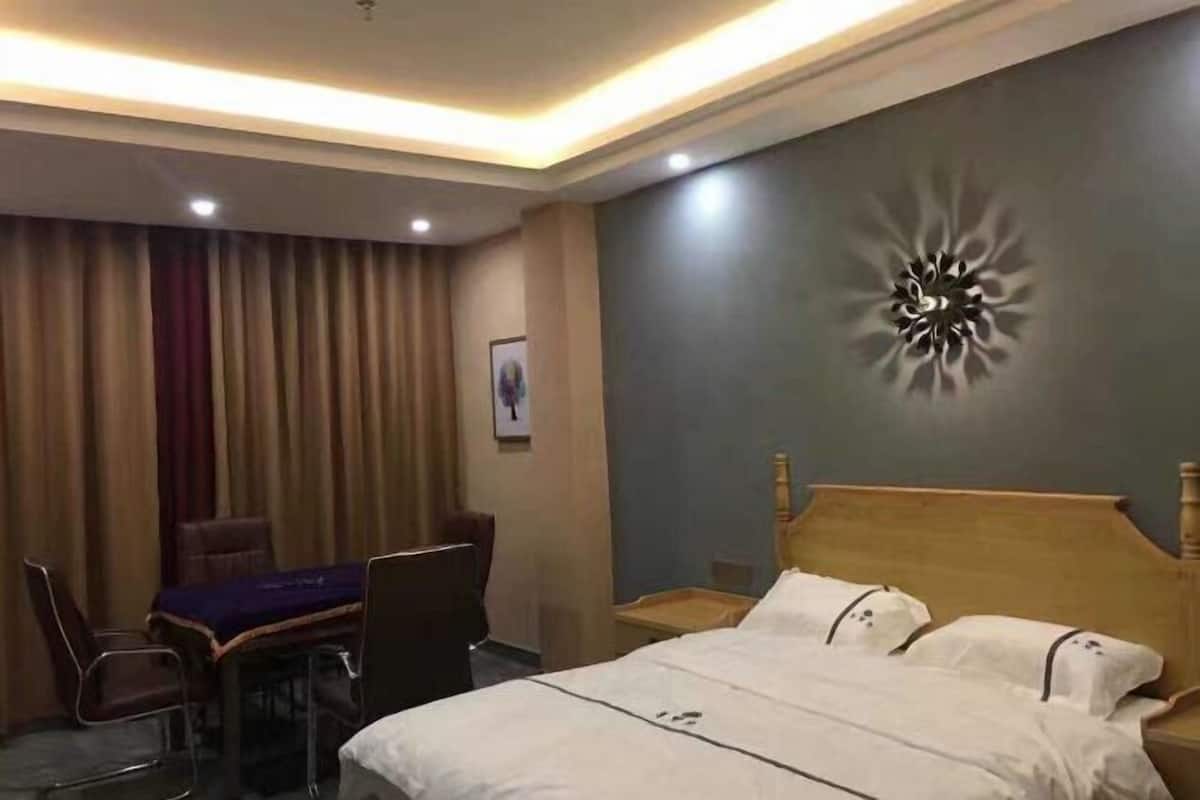 A hotel room with a bed, a desk, and a chair.