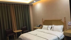 A hotel room with a bed, a desk, a chair, and a nightstand. - Danzhou xillelai theme travel rental (Danzhou)