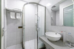 A modern bathroom with a glass-enclosed shower, a white sink, and a large mirror. - Lianyungang Xingjia Business Hotel (Suxin Kuai Station Branch) (Lianyungang)