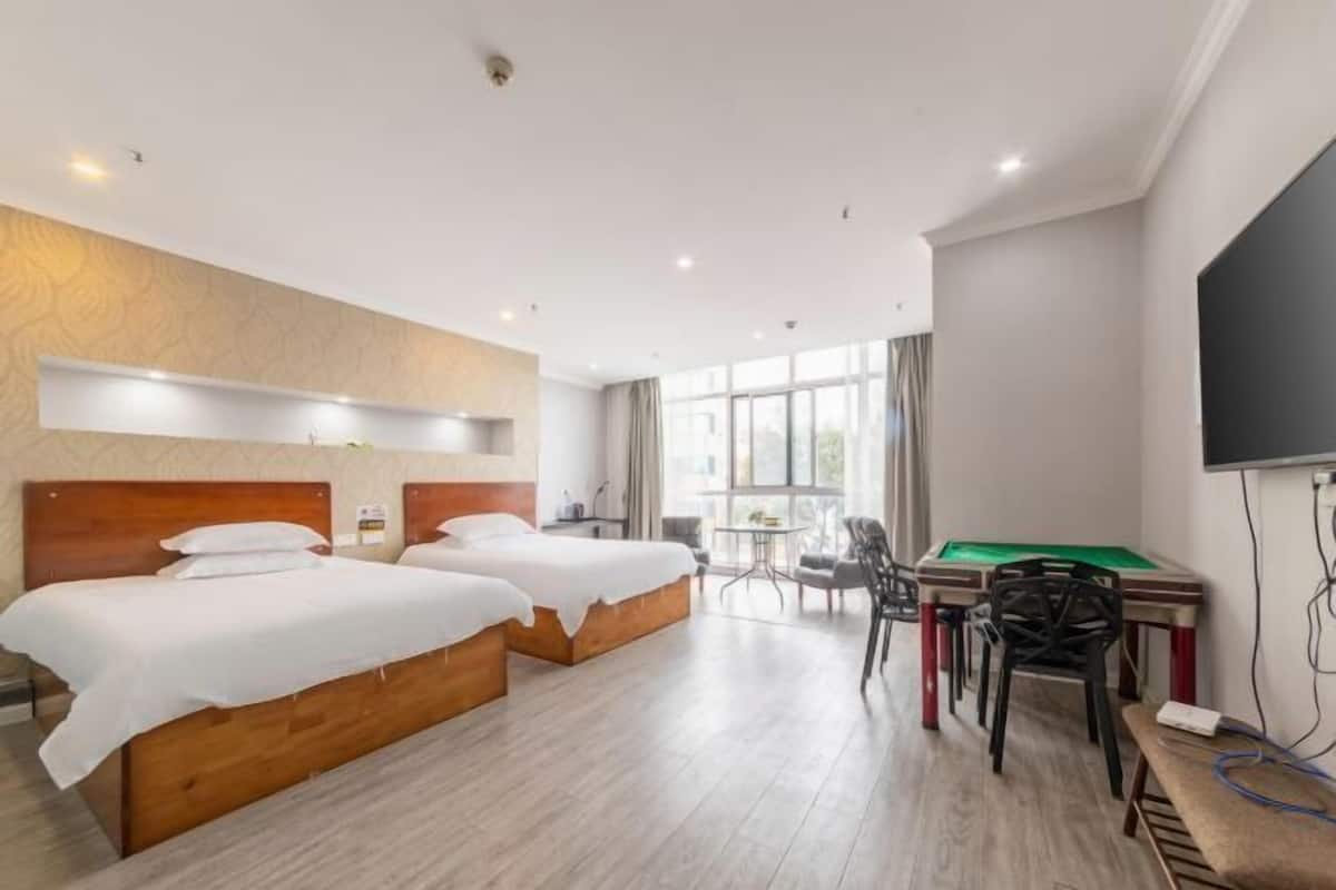 Ein Hotelzimmer mit zwei Betten, einem Billardtisch und einem Fernseher.