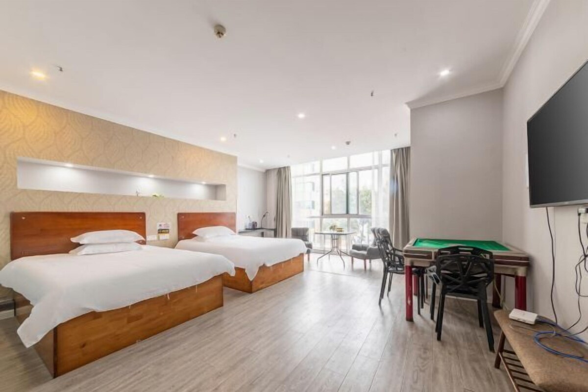 A hotel room with two beds, a pool table, and a television.