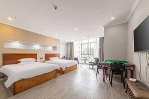 A hotel room with two beds, a pool table, and a television. - Lianyungang Xingjia Business Hotel (Suxin Kuai Station Branch) (Lianyungang)