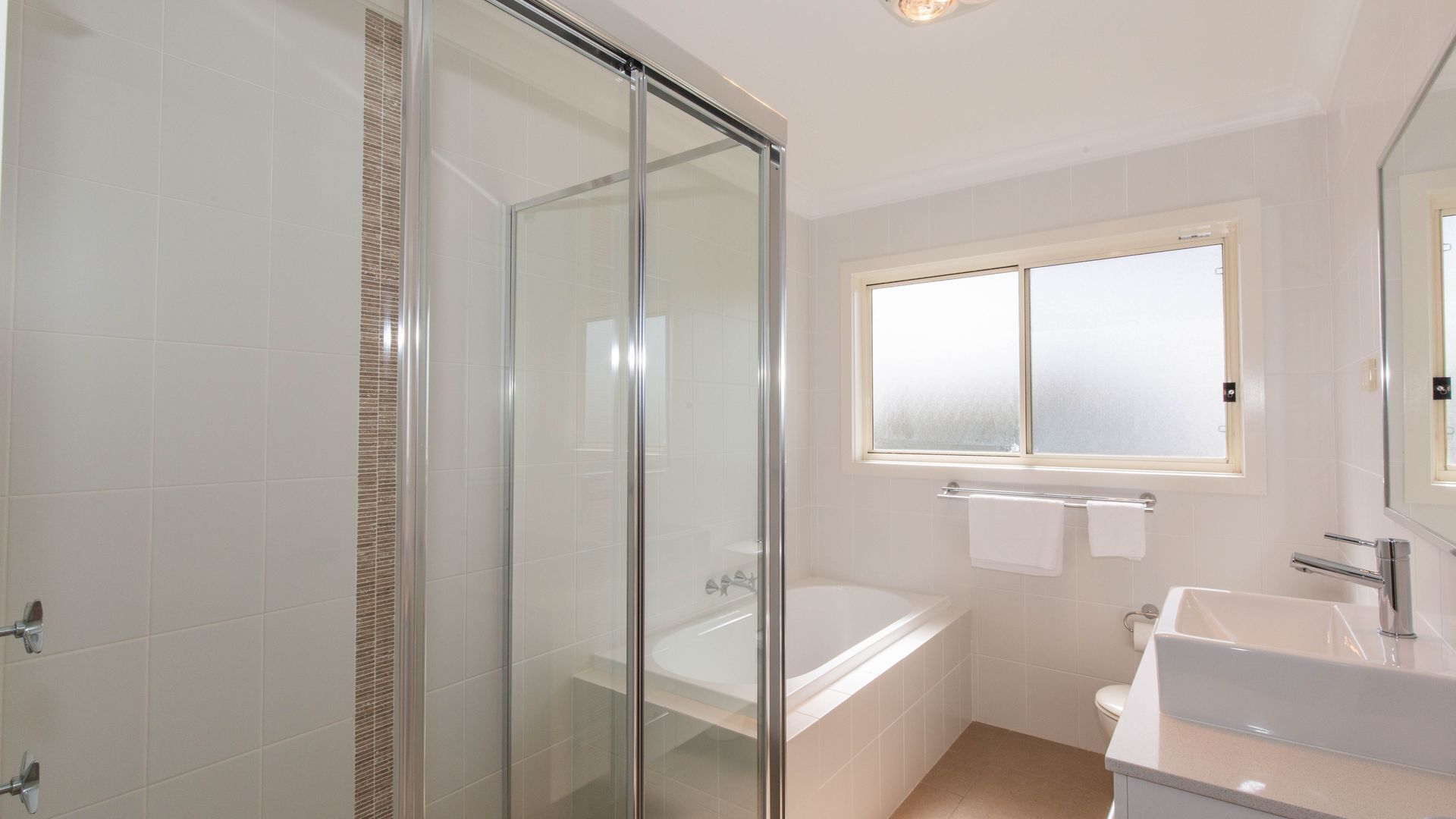 Une salle de bain moderne avec une douche à parois de verre, une baignoire, des toilettes et un lavabo.