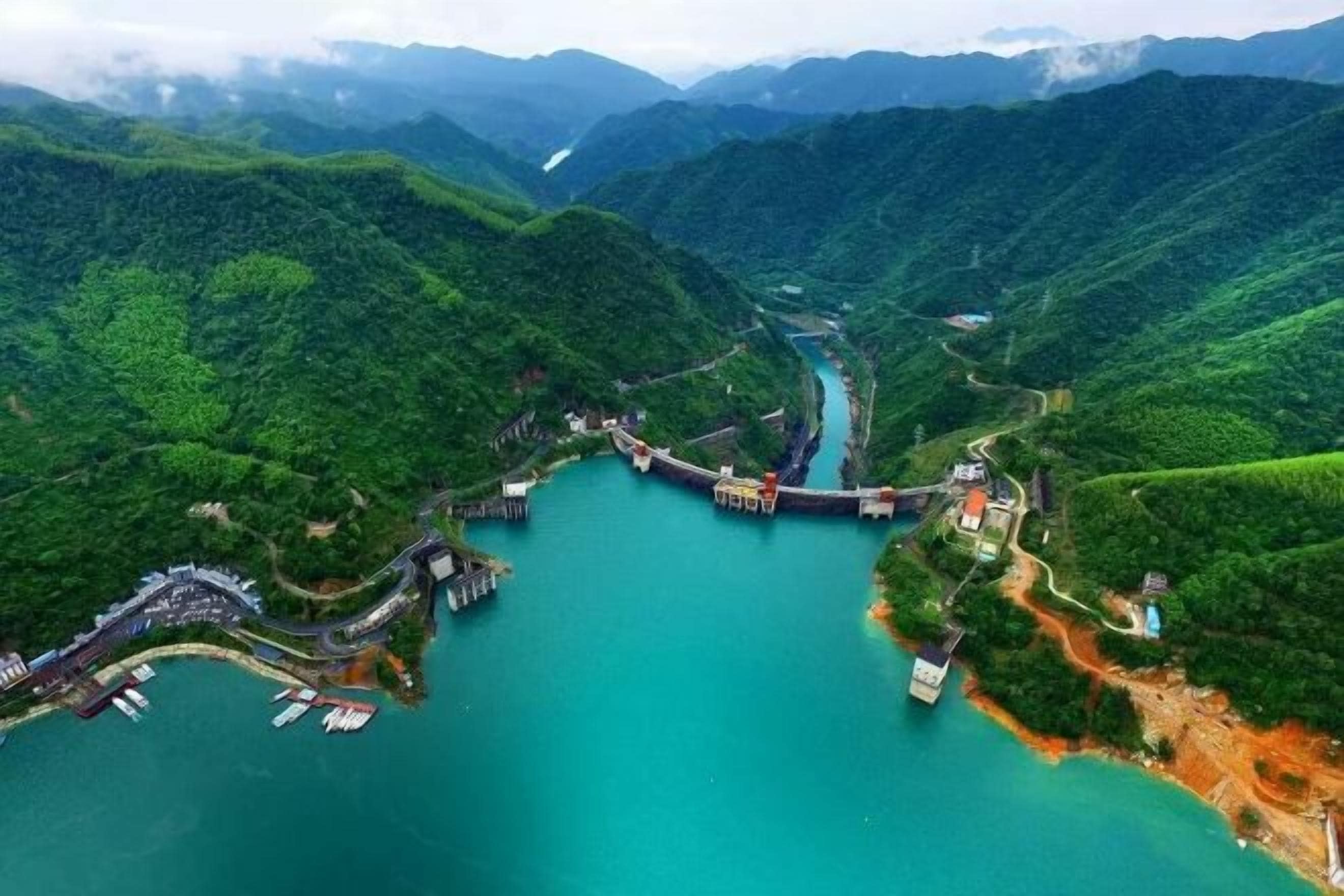 An aerial view of a coastal area with a river, a bridge, and a dock.