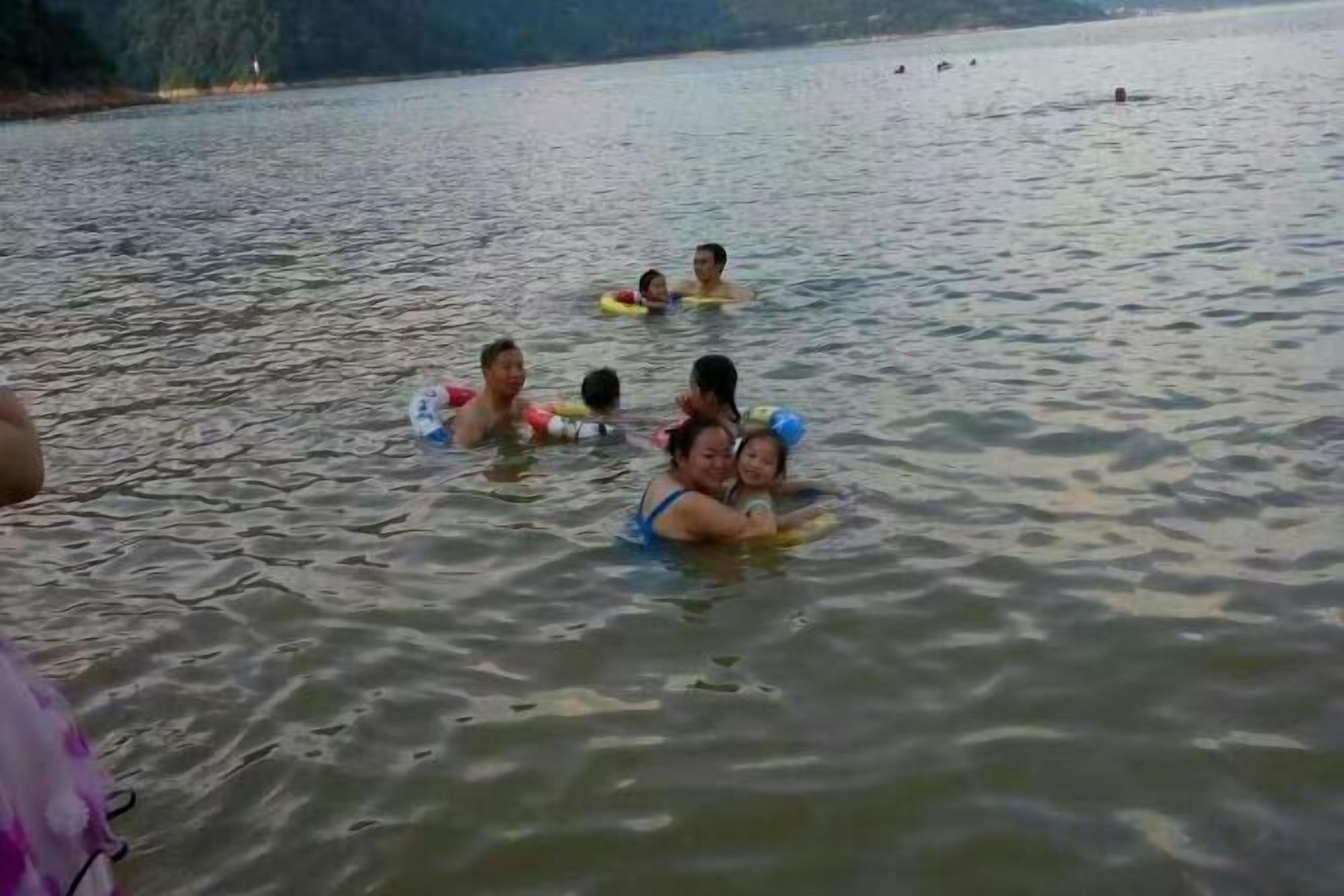 Un grupo de personas en el agua, algunas flotando y otras nadando.