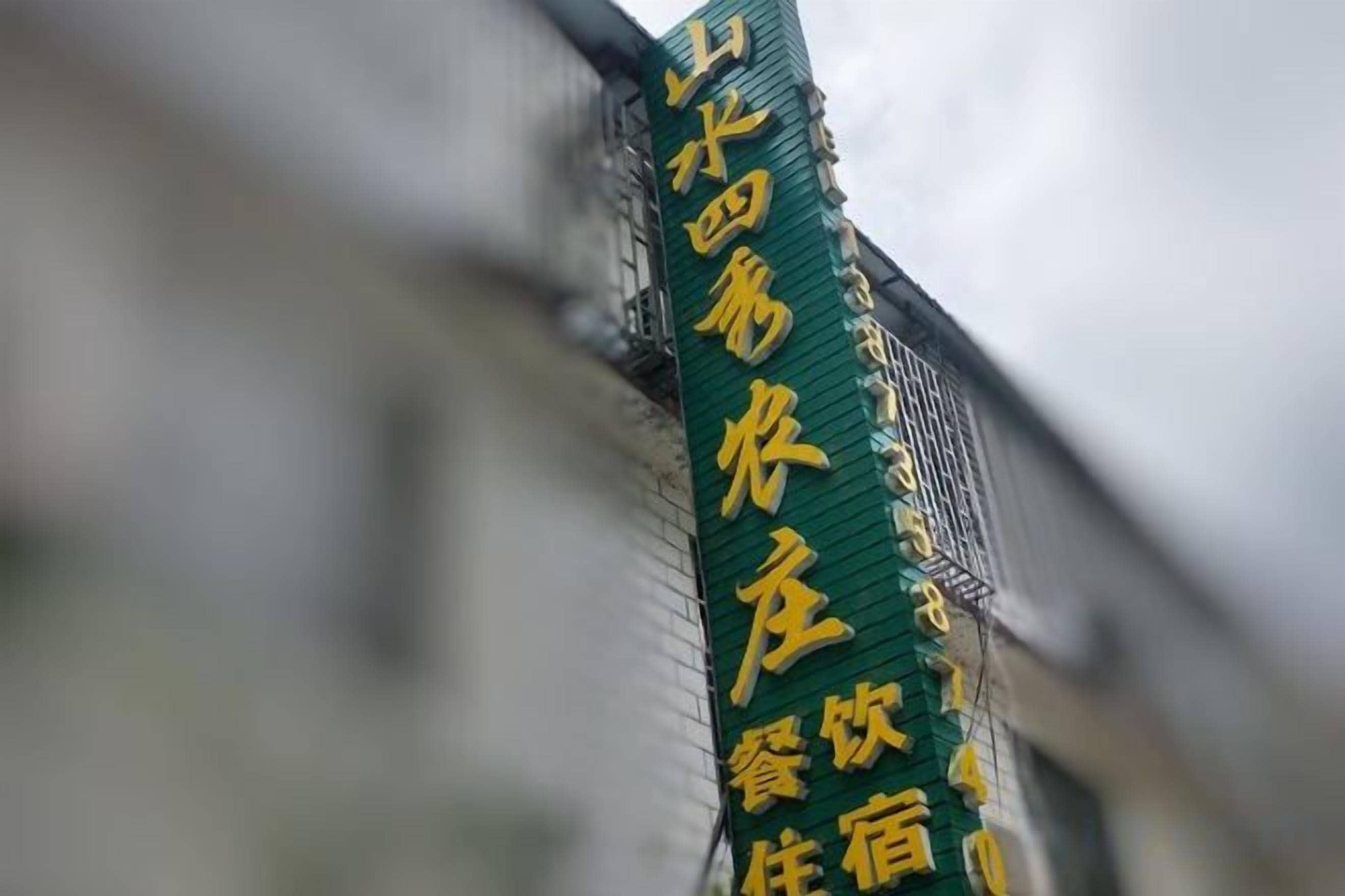 A vertical sign with text, likely indicating a hotel or establishment.
