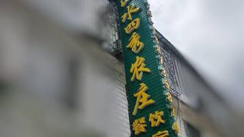 A vertical sign with text, likely indicating a hotel or establishment.