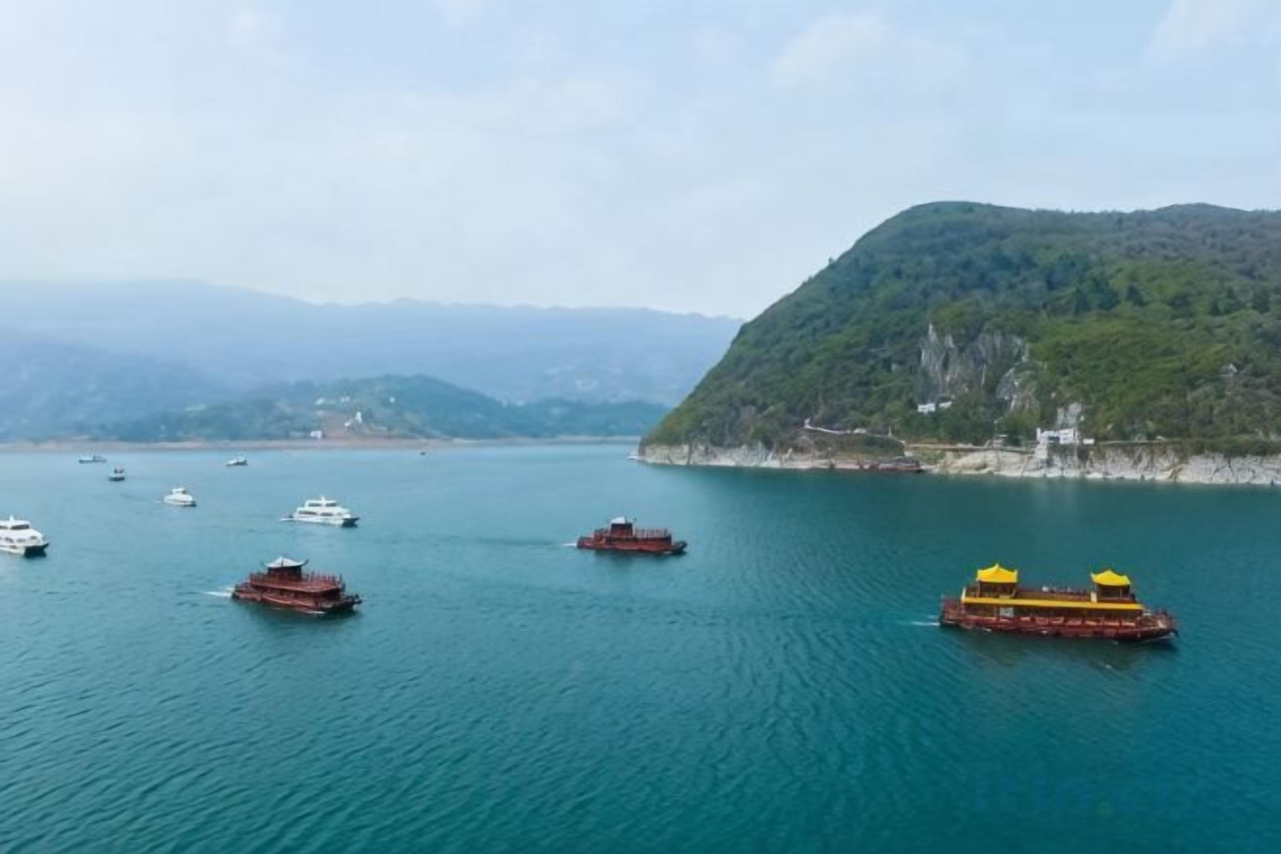 A calm body of water with boats and a hilly landscape in the background.