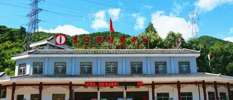 A building with a traditional architectural style, a red flag on top, and a sign with Chinese characters.