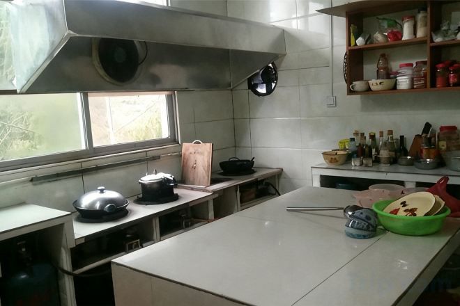 A kitchen with a large island, stainless steel appliances, and a window.