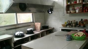 A kitchen with a large island, stainless steel appliances, and a window.