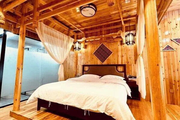 Ein Zimmer mit Holzboden, einem Bett, einer Wanduhr und einer Pendelleuchte.