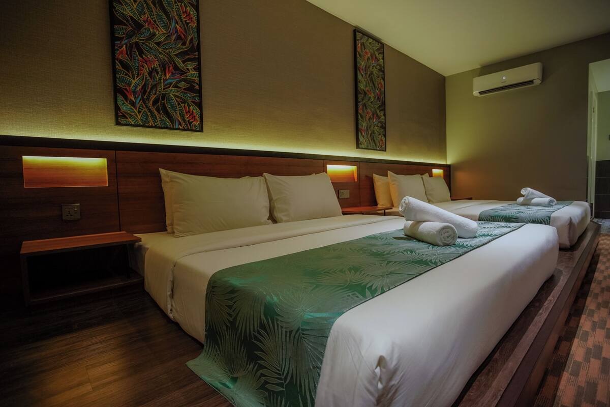 A hotel room with two beds, a wooden headboard, and a large wall art piece above the beds.