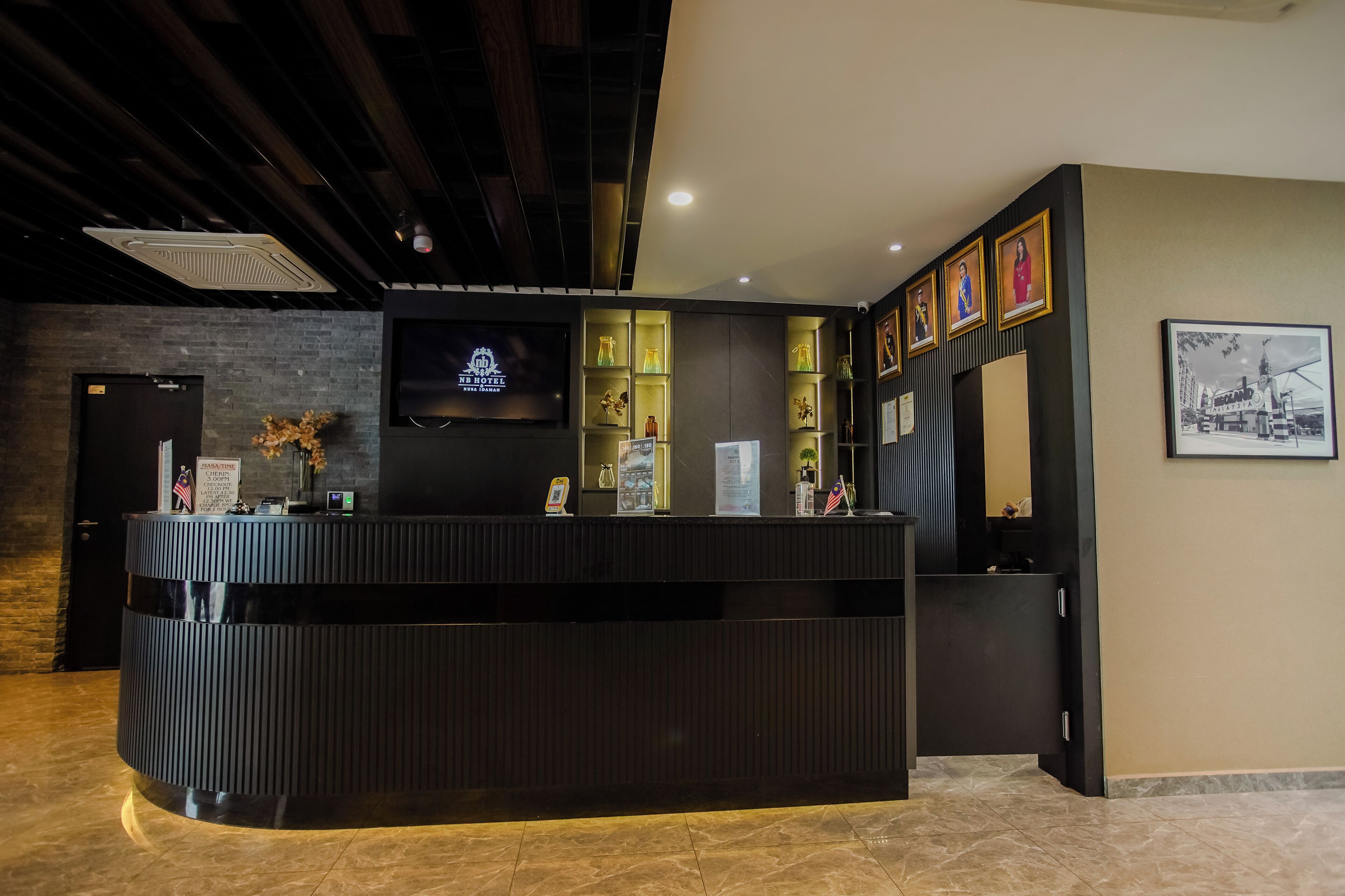 A reception area with a modern design, featuring a black reception desk, a flat-screen TV, and a wall-mounted display.